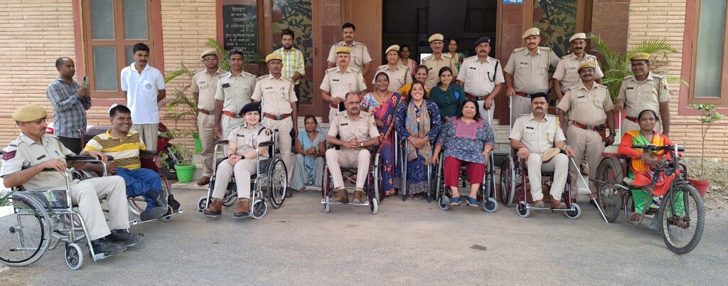 A picture of several police men in a wheelchair and women in wheelchair , who all are smiling at the camera for picture.