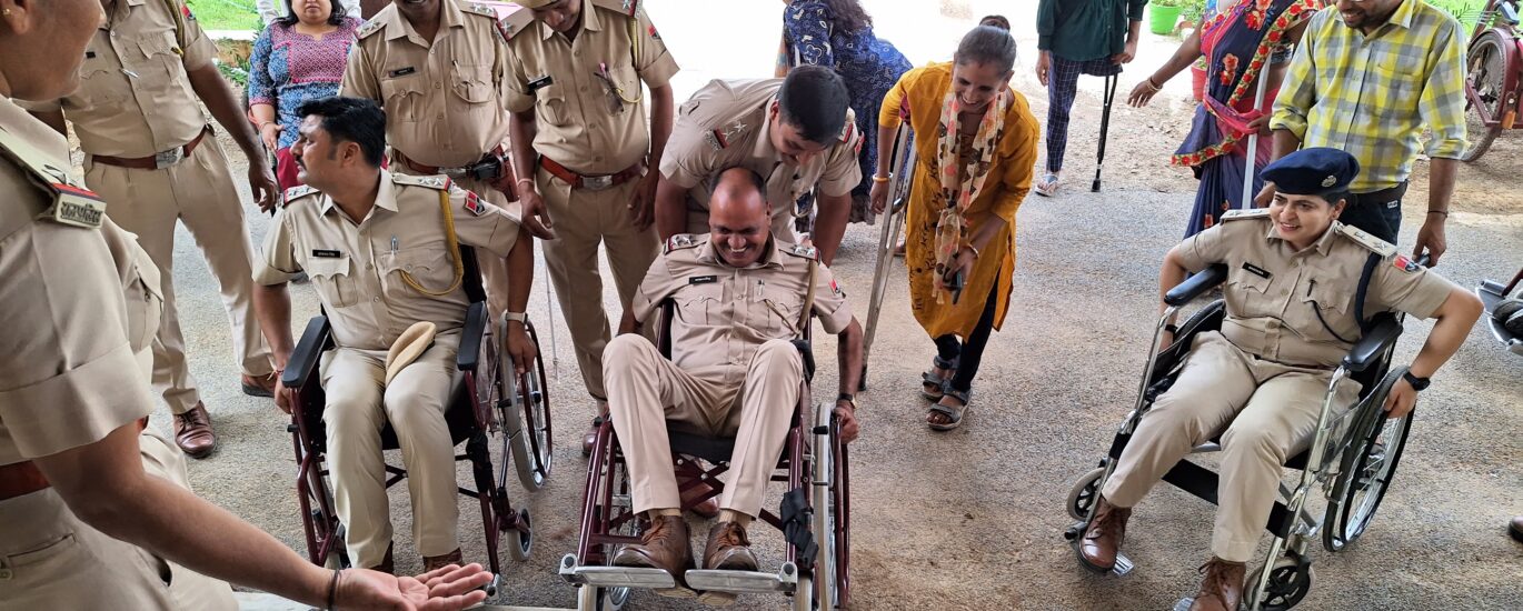 Police officers and civilians using wheelchairs and crutches gather near a building entrance with stairs, highlighting accessibility challenges.