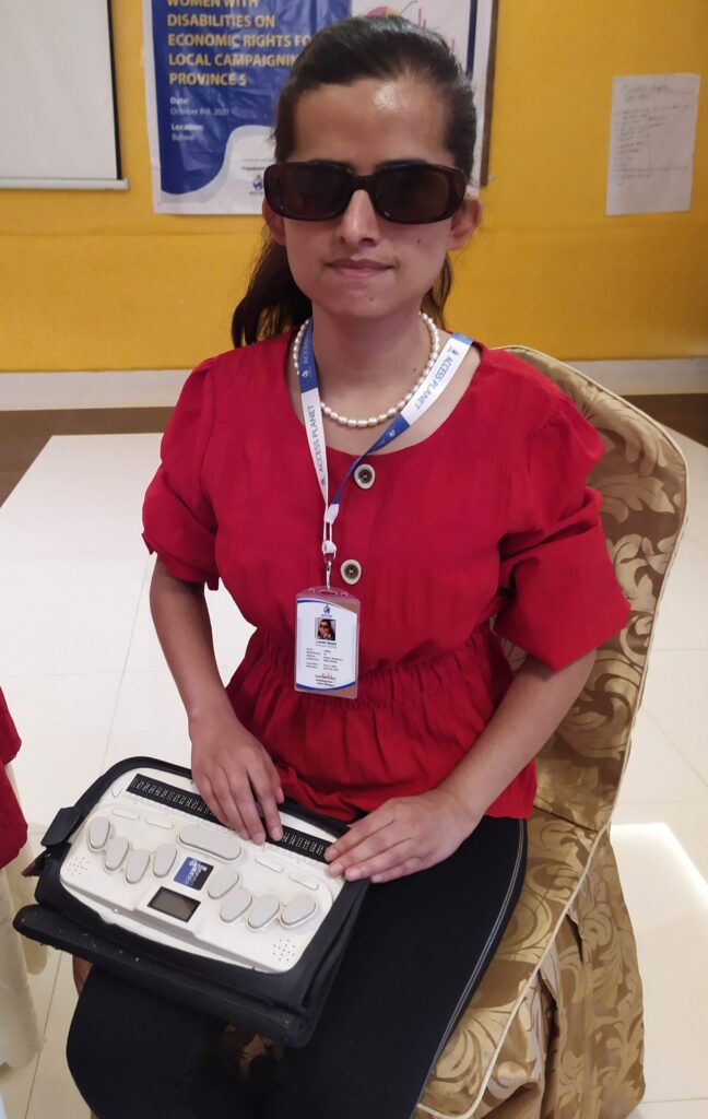 A picture of a woman wearing black glasses, using something with her hands.