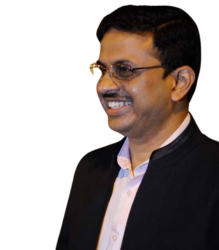 Mr. D. Chakravarti wearing a black coat and smiling