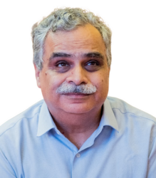 Mr. Dipendra Manocha, is wearinf a light color shirt with neatly trimmed hair.