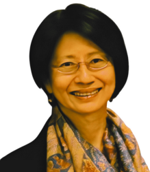 Ms. San Yuenwha, is wearing a top and scarf with specs and is looking towards the camera with a smiling face.