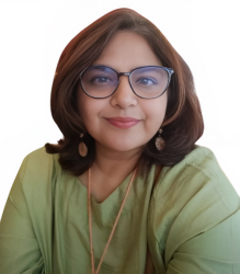 Image of Ms. Shalini Khanna, wearing a green color kurta with golden jewellery and specs.