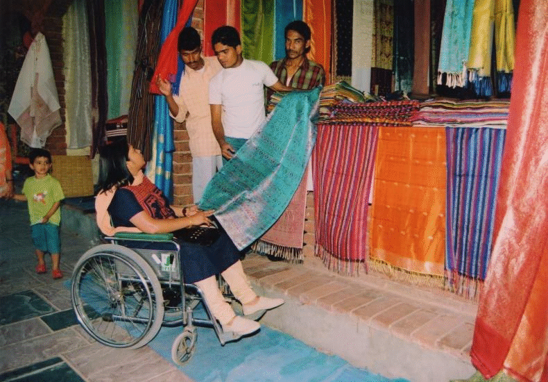 A lady in wheelchair choosing clothes in a shop